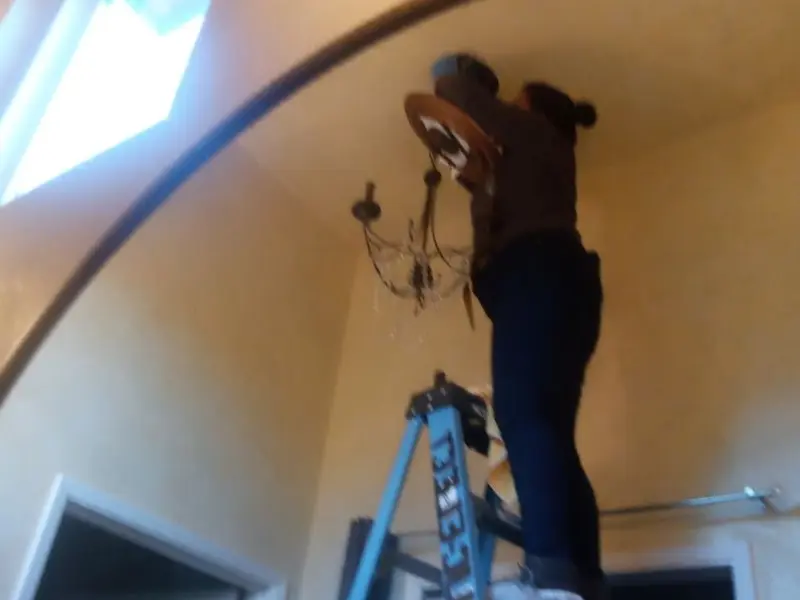 Electrician installing a chandelier in a Glencoe residence